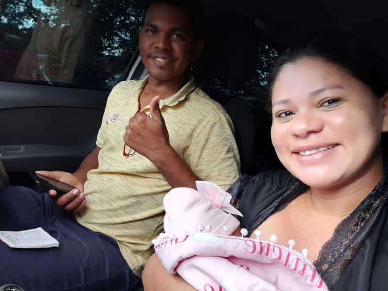 Adriana com Emanuelle Farias nos braços. Ela está ao lado do esposo Everton.